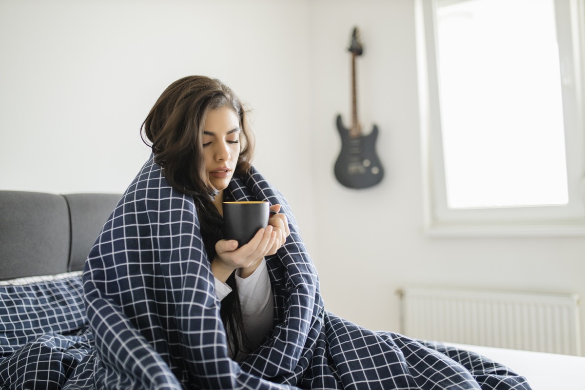 A sick woman lying in bed suffering from high fever.  Cold flu and migraine