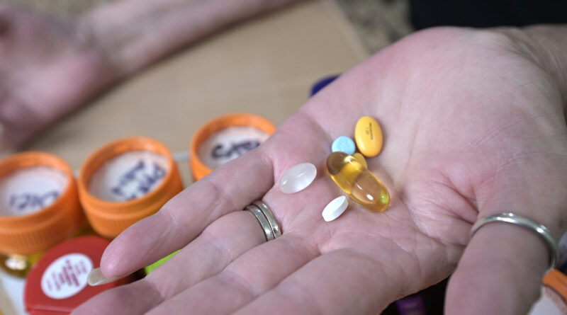 A woman holds some prescription drugs.